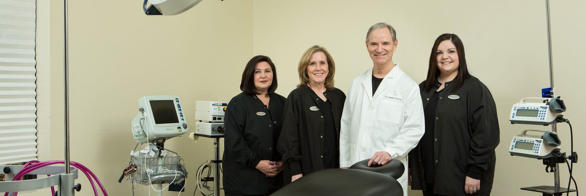 Dr. Stephen Lazarus, Cathy Seagle, Marguerite Graham, and Ashley Larkin posing for a photo in their Knoxville plastic surgery office